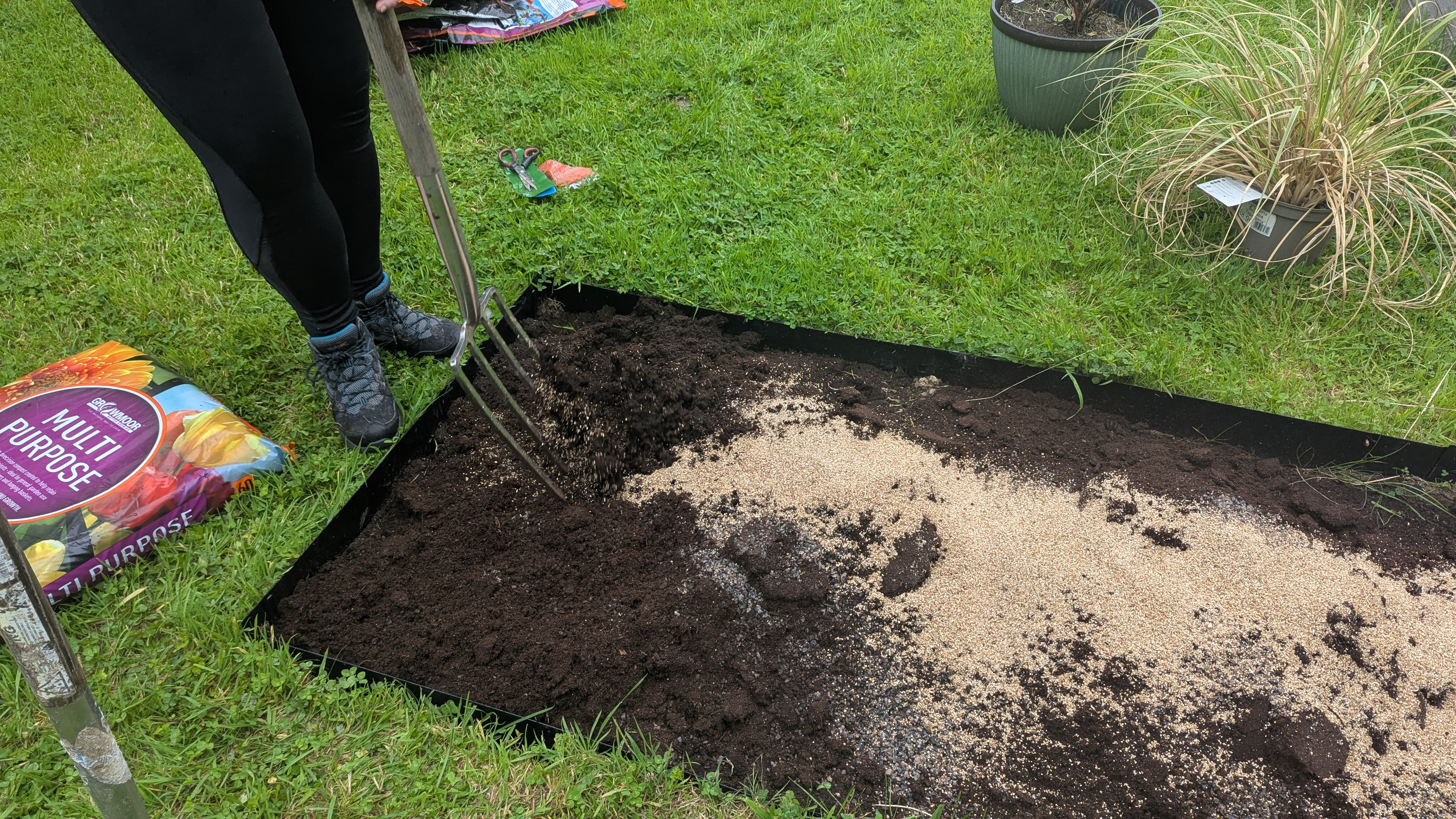 Forking perlite and compost through a new planting bed near Whitland, with a Cordyline waiting in its pot beside it